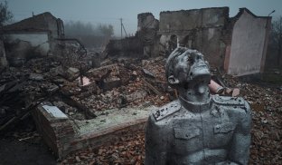 Статуя радянського солдата на тлі зруйнованого ракетним обстрілом будинку культури на околиці міста Авдіївка 26 жовтня 2023 року Фото Getty Images